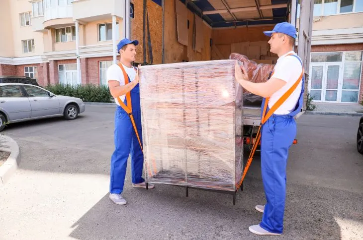 Umzugshelfer tragen Kommode mit Gurt Umzugshelfer tragen Kommode mit Gurt